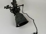 a bell with a chain attached to it and a key attached to it