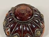 a close up of a small vase on a white surface