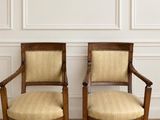 deux chaises en bois posées sur un parquet, près d'un mur blanc