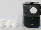 a black coffee maker sitting on a table next to cups
