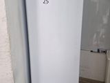 a white refrigerator in the corner of a bathroom