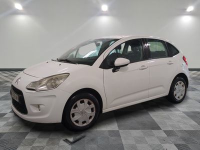 la petite voiture blanche est garée sur un carrelage à carreaux