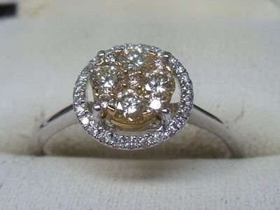 une photo d'une bague en diamant posée sur un tissu blanc