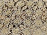 une vieille nappe au crochet ornée d'un motif de fleurs et de feuilles