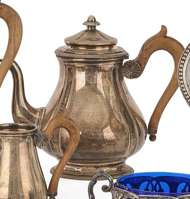 une théière en argent et un bol en verre bleu