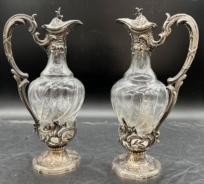 deux vases en argent posés l'un à côté de l'autre sur une table