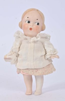 a small doll that is standing on a white surface