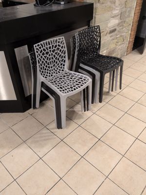 three chairs sitting in front of a counter in a restaurant