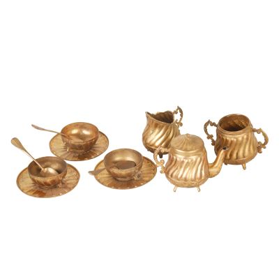 brass tea set with cups, saucers and spoons on a white background