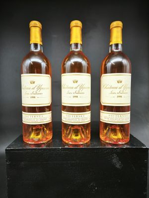 trois bouteilles de vin posées sur une caisse en bois