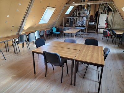 une pièce équipée de tables et de chaises, avec une verrière