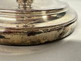 a silver plate with a lid sitting on a table