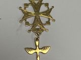 an image of a gold cross with a bird charm hanging from it