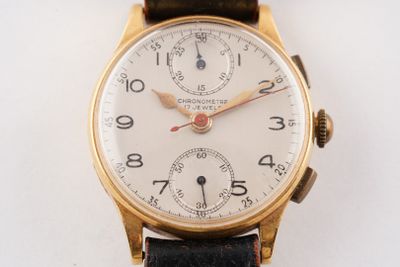 une montre-bracelet en or avec un cadran blanc et un bracelet en cuir noir