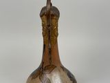 a vase with a bird on it sitting on a table