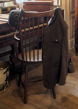 un manteau accroché au dossier d'une chaise devant un piano