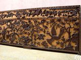 un grand panneau en bois orné d'oiseaux et de fleurs