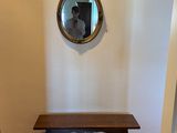 a wooden bench in a room with a mirror on the wall