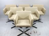 six chaises beiges dans une pièce au sol blanc et au mur blanc