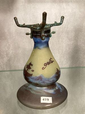 un vase muni d'une anse, posé sur une étagère en verre