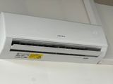 an air conditioner sitting on top of a white shelf next to a window