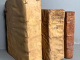 three old books sitting on top of a table next to each other