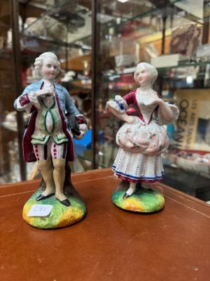 two figurines of a man and a woman standing on a table