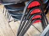 several black and red chairs are lined up on a wooden floor