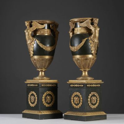 deux vases noirs et dorés posés l'un sur l'autre