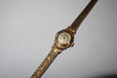 an image of a gold wrist watch on a white surface