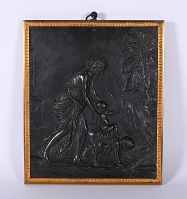 une plaque en bronze représentant une femme et un enfant accompagnés d'un chien