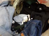 a pile of clothes that is on a bed