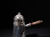 an antique silver coffee pot with a wooden handle on a black background