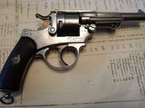 un pistolet posé sur une feuille de papier