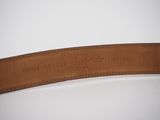 a close up of a brown leather belt on a white surface