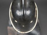 a close up of a helmet on a stand on a black background