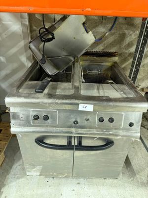 a silver stove with a fryer on top of it in a warehouse
