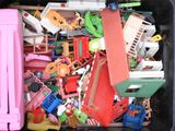 un bac noir rempli de jouets et un petit camion rose