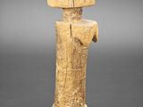 une statue en bois d'un homme avec un chapeau sur la tête
