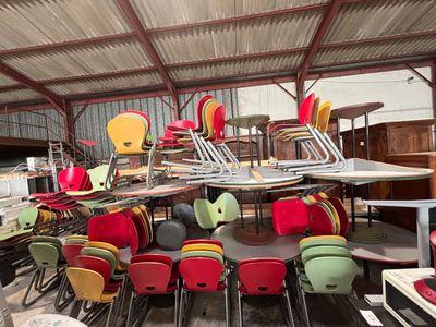 de nombreuses chaises et tables dans une pièce couverte
