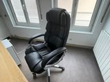 une chaise de bureau noire placée devant une fenêtre