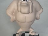 une figurine représentant un personnage de dessin animé posée sur une surface à carreaux