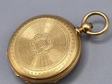 an antique gold pocket watch with a chain hanging from it ' s side