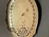 a gold plate with a design on it on a wooden stand