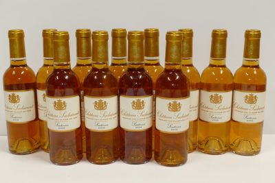 six bouteilles de vin sont alignées sur une surface blanche