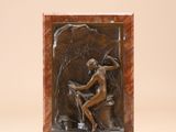 une image représentant une sculpture d'une femme assise sur un rocher