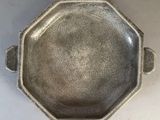 a silver bowl with a handle on a table