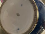 a blue and white tea pot with a gold rim