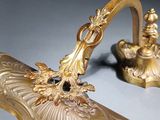 a gold colored object with a dragon on top of it