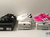 trois paires de chaussures sont posées sur des cartons, sur une table